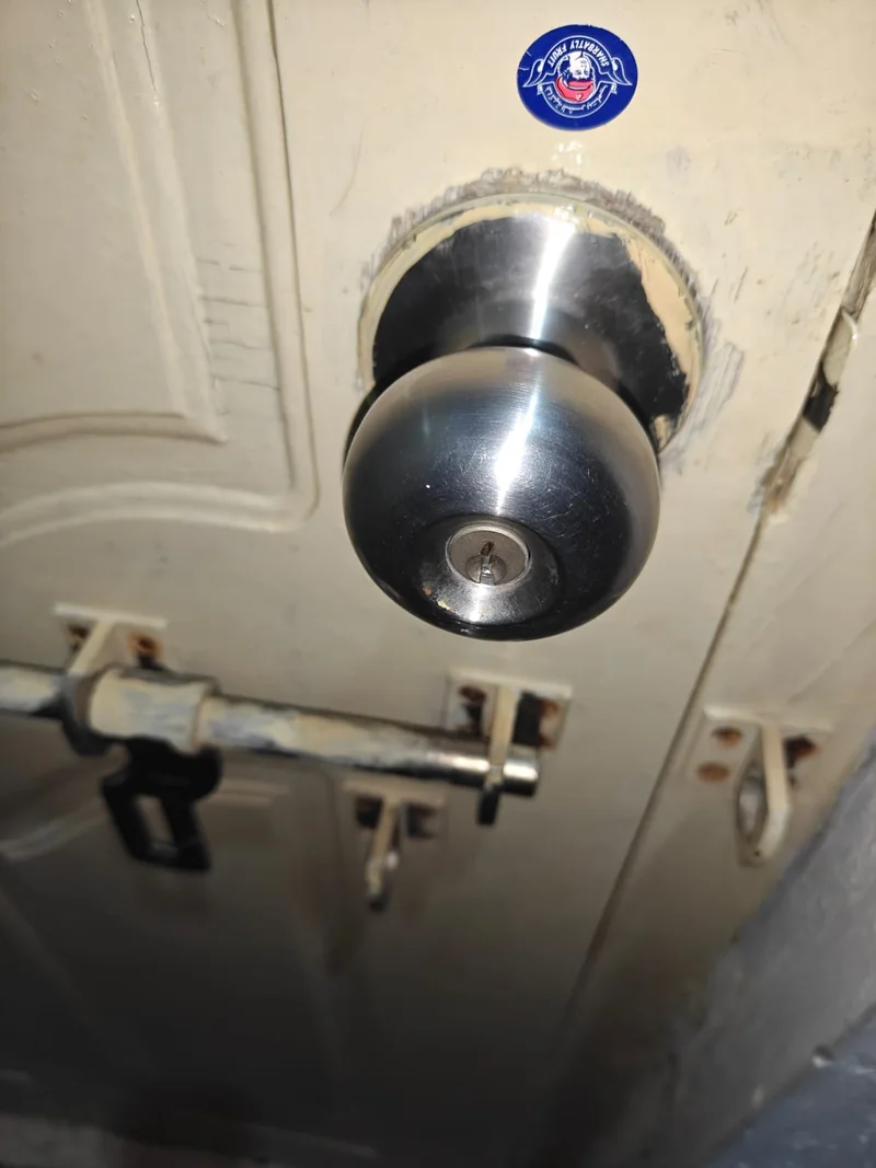 Metal door knob lock and sliding bolts on a cream door